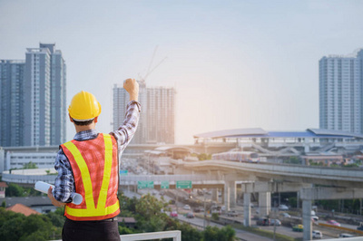 工程师或建筑师与防护安全帽检查建筑图纸呼叫支持团队在建筑工地。工程建筑和建筑施工理念。软焦点